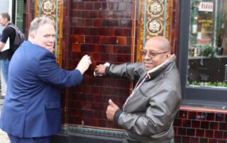 Executive Mayor Jason Perry at Crystal Palace blitz cleaning the exterior of a bar with a trader