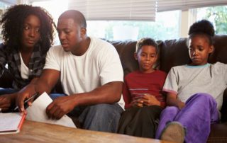 A family sitting on a sofa