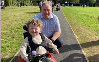 Mayor Jason Perry with a young boy in a powered wheelchair