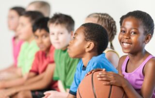 Children lined up ready to play basketball.