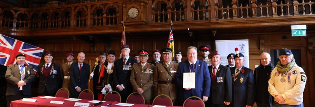 Mayor Perry stands with members of the military in Braithwaite Hall after signing the Armed Forces Covenant.