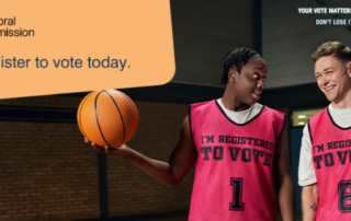 Young man holding a basketball and wearing a register to vote vest