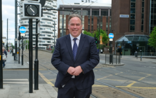 Mayor Perry stands in Croydon town centre with the 50p building behind him.